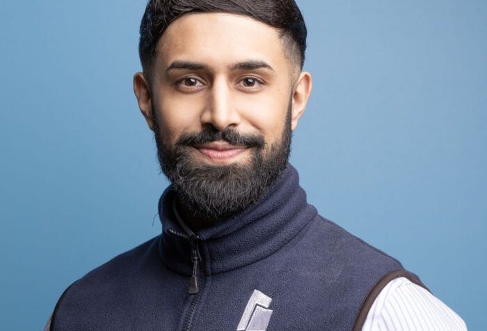 Jaskaran Singh, Principal Commercial Consultant at Brookbanks stood in from of a plain blue background