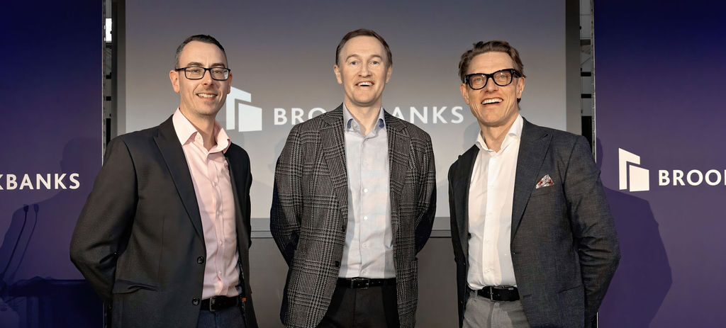Richard Moorcroft, Andrew Thorley and Paul Boileau of Brookbanks. They are stood in front of a dark blue wall featuring the Brookbanks logo.
