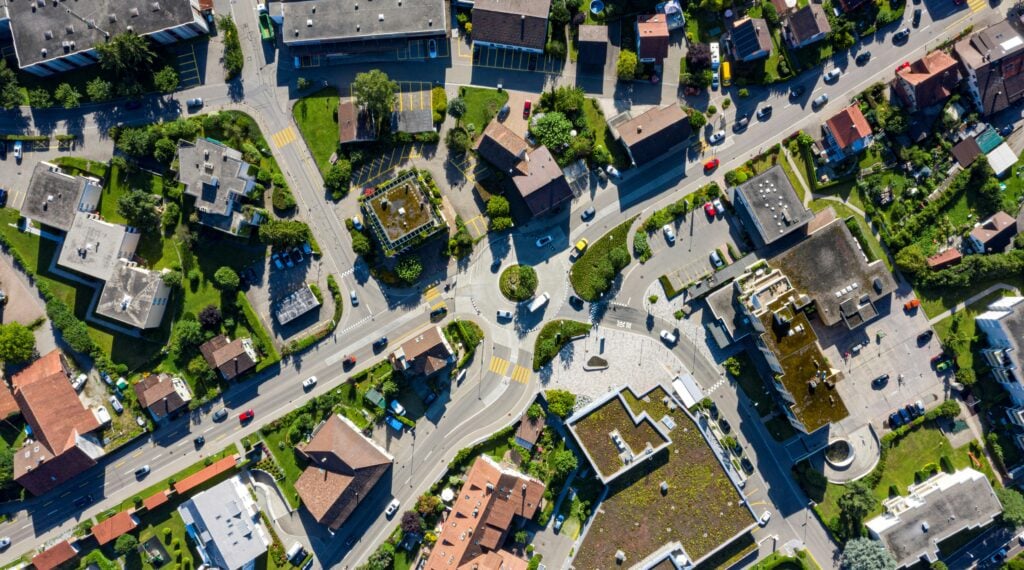 An aerial view of houses surrounding a road featuring a roundabout