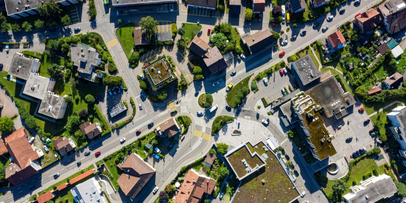 An aerial view of houses surrounding a road featuring a roundabout