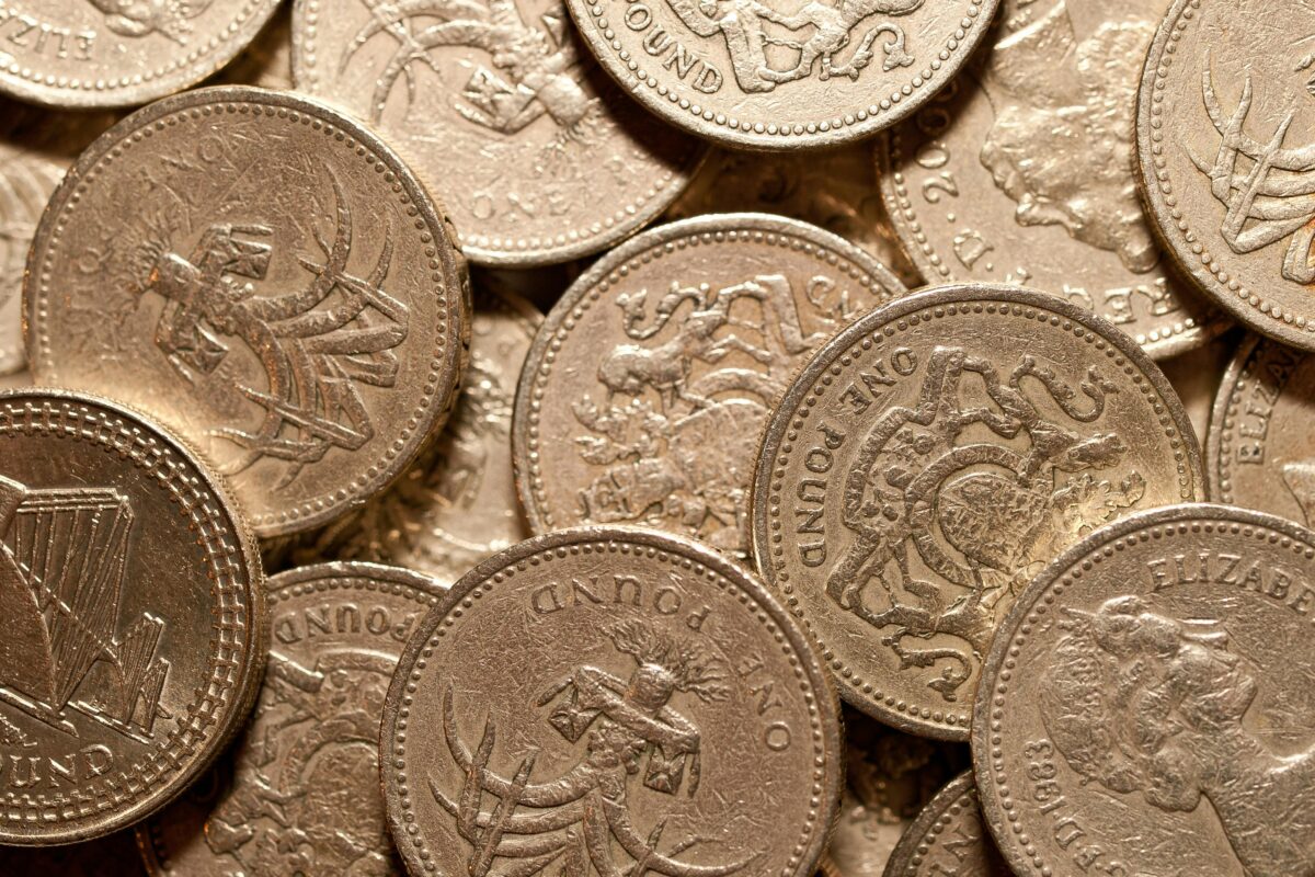 Macro shot of golden British pound coins showcasing intricate designs and details.