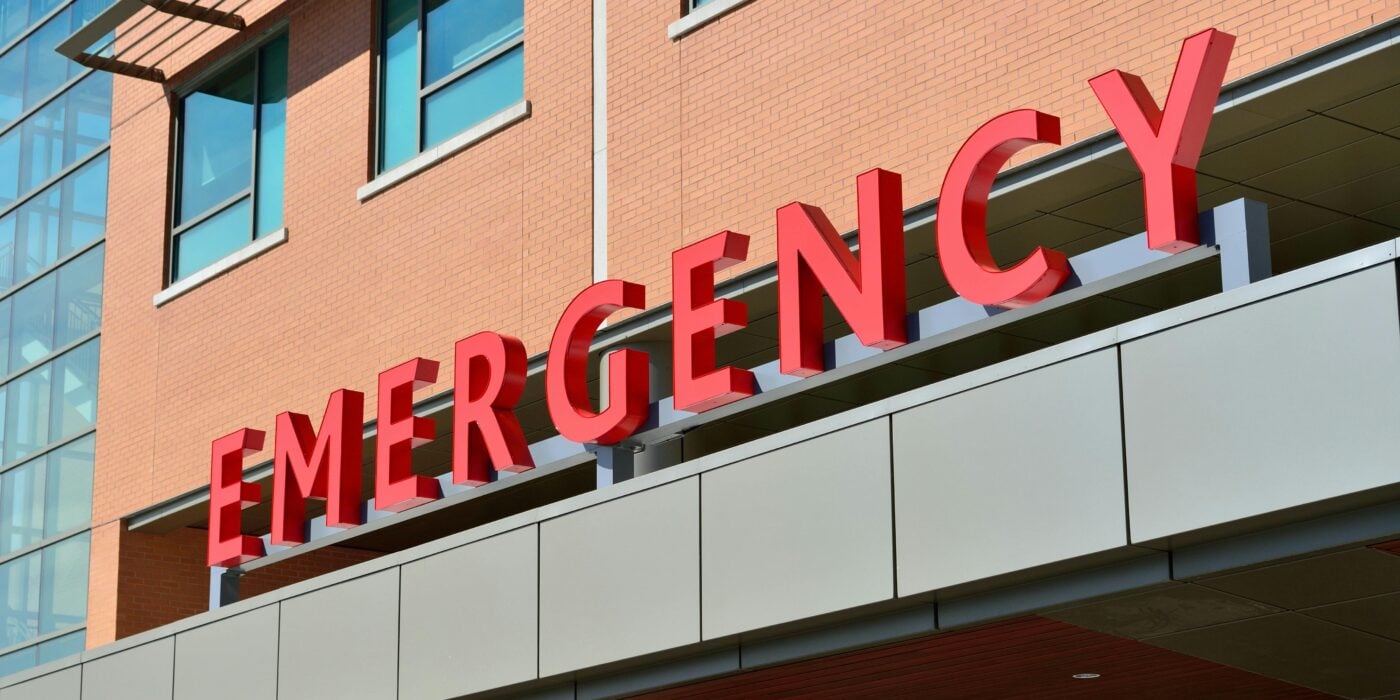 Close-up of a modern hospital emergency room entrance with prominent red letters.
