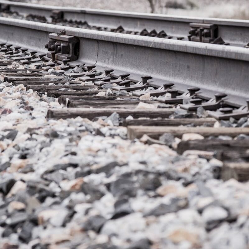 Close-up view of a curved railroad track in a rocky landscape.