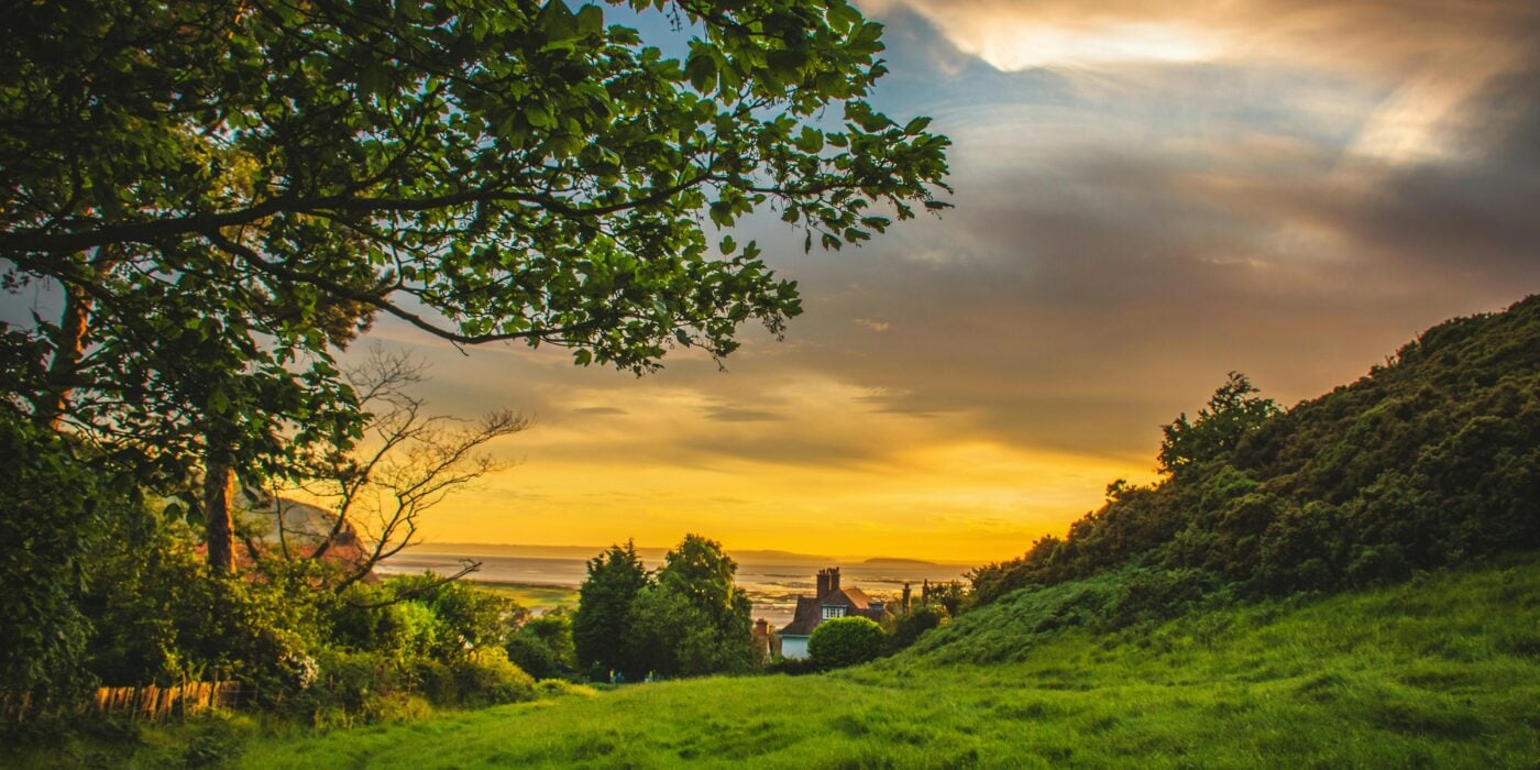 A picturesque sunset over the lush, green countryside of Deganwy, Wales, capturing nature's beauty.