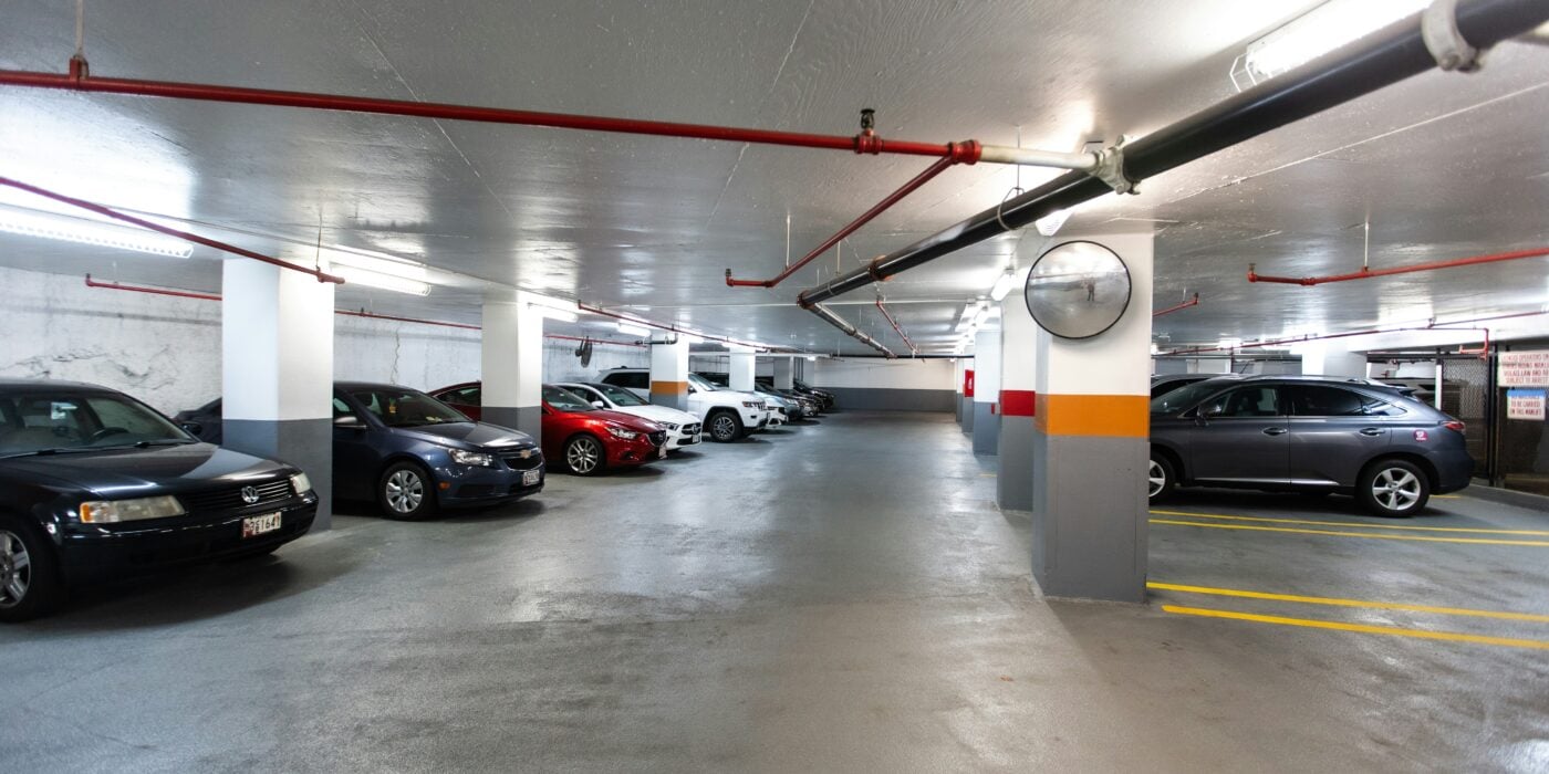 An underground car park with concrete flooring and supporting concrete pillars