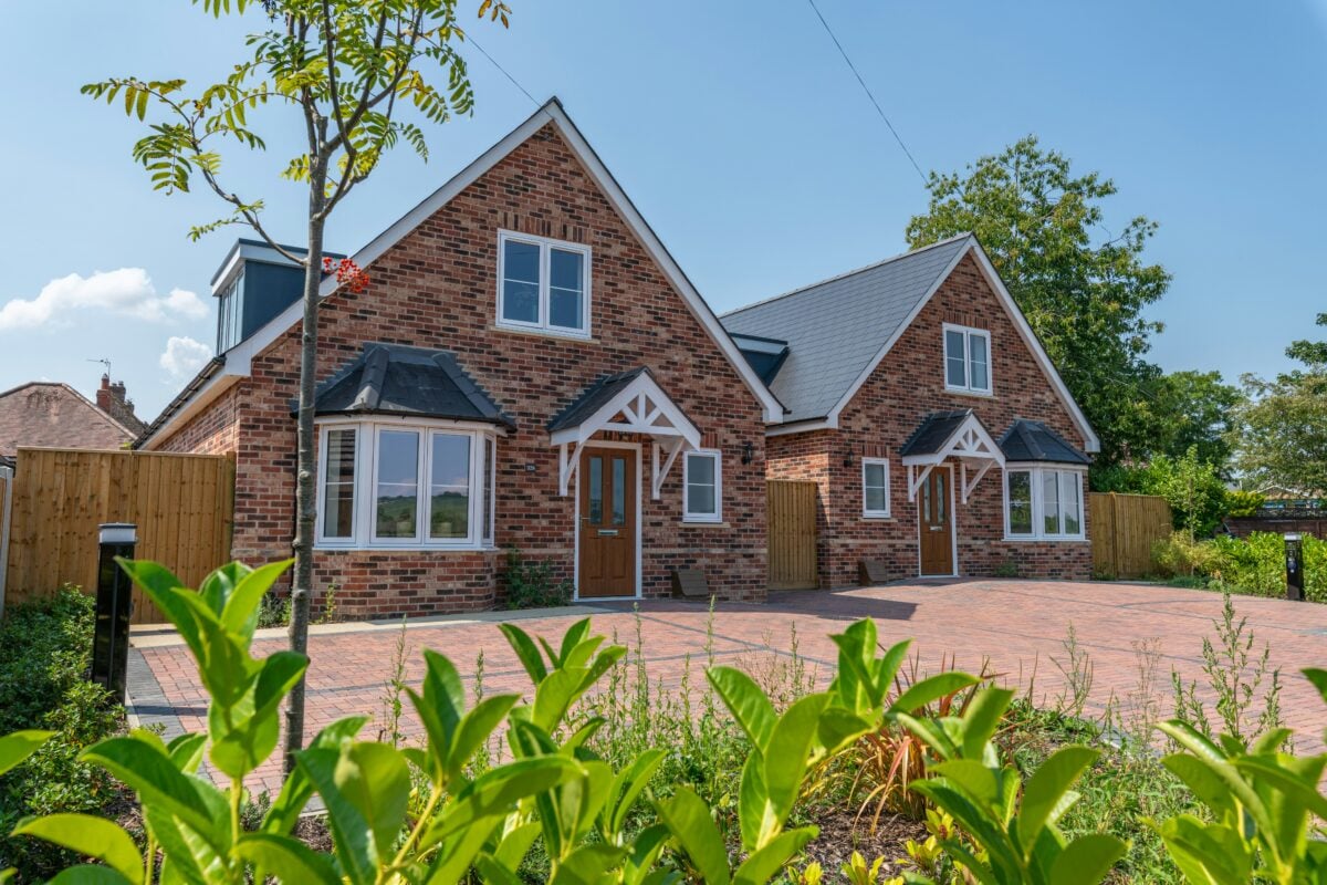 Two red brick dorma bungalows with a redbrick driveway, built by an SME house builder in the UK.