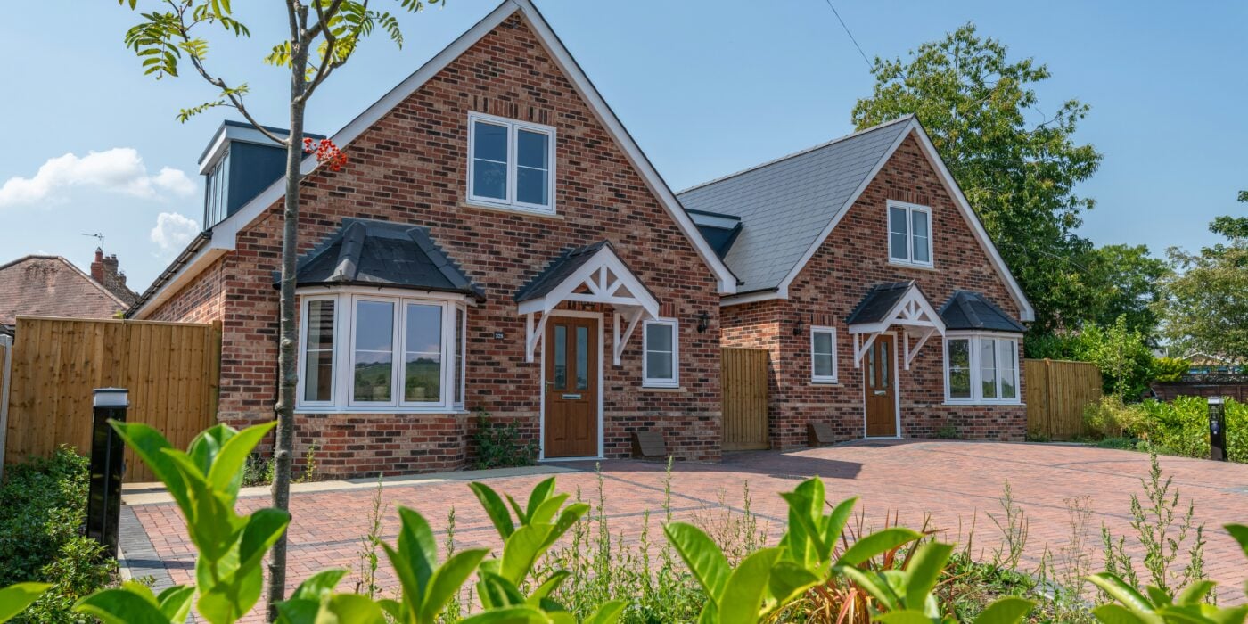 Two red brick dorma bungalows with a redbrick driveway, built by an SME house builder in the UK.