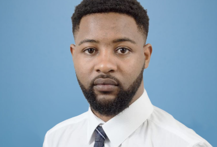 Gerrad Mukuyu, cost consultant at Brookbanks, stood against a blue wall