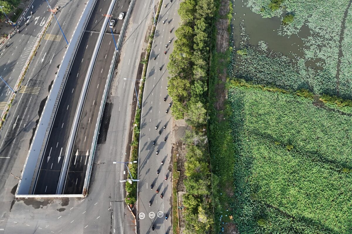 A stunning aerial view showcasing a contrast between urban roads and a lush green wetland.
