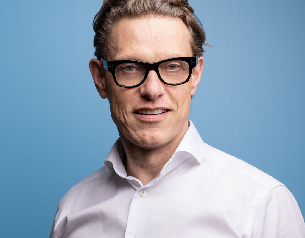 Paul Boileau Chairman of Brookbanks stood in front of a pale blue background