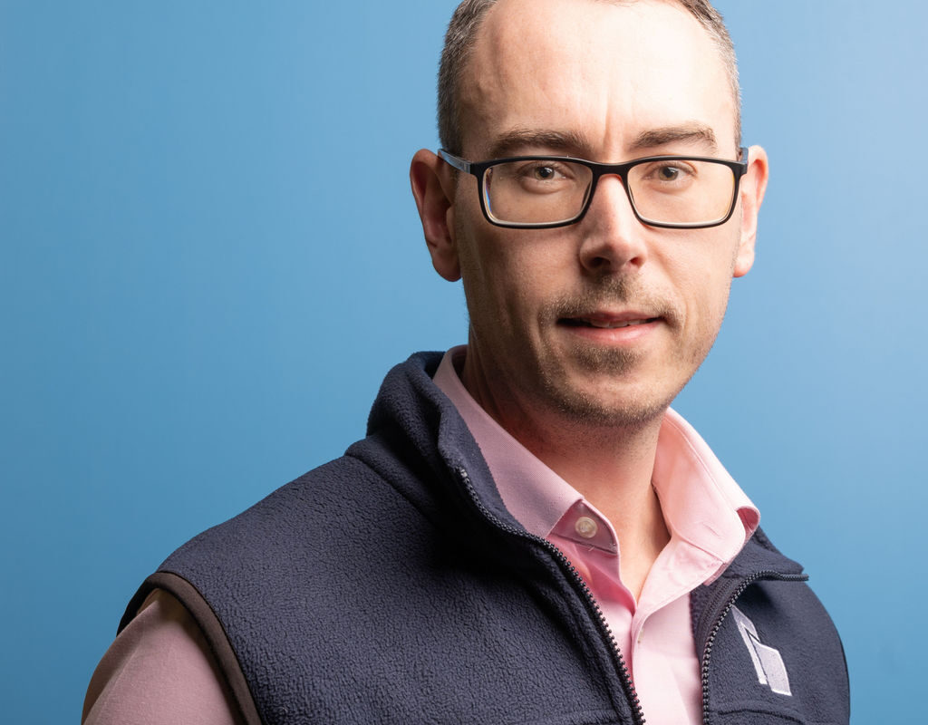 Richard Moorcroft Chief Technical Officer at Brookbanks stood in front of a pale blue background