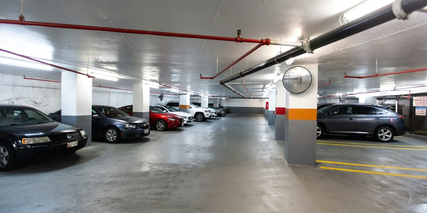 An underground car park with concrete flooring and supporting concrete pillars